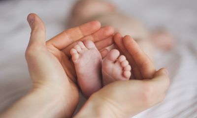 Kinderfüße in Hände